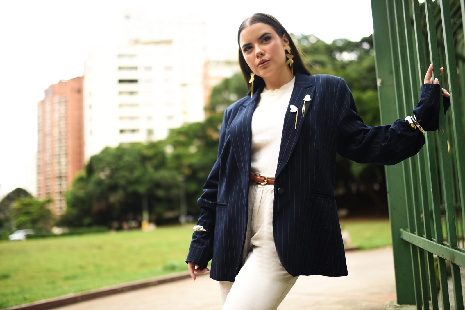 Sophia Ferreira, UGC Creator e criadora de conteúdo digital, posa com um look sofisticado e alfaiataria elegante em um cenário urbano ao ar livre, transmitindo confiança e estilo.