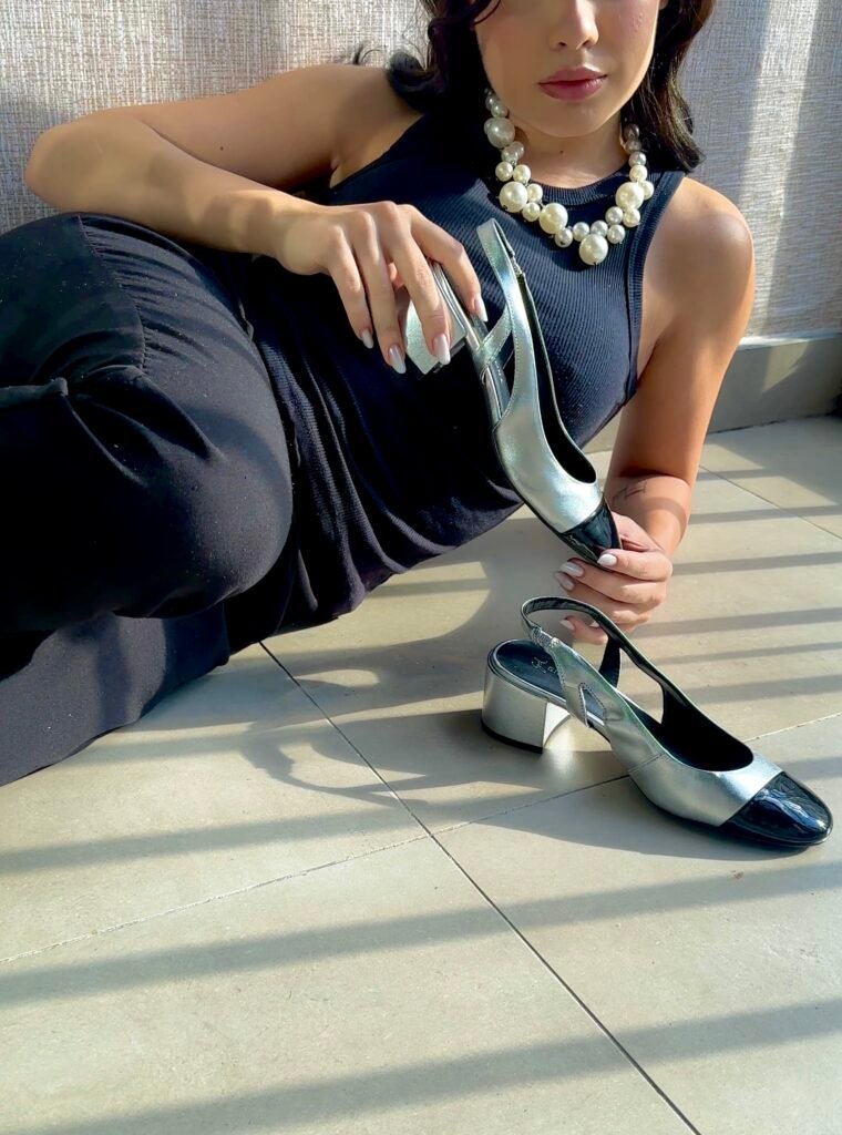 Sandália slingback prateada Giulia Domna com detalhe preto, realçando sofisticação e conforto.