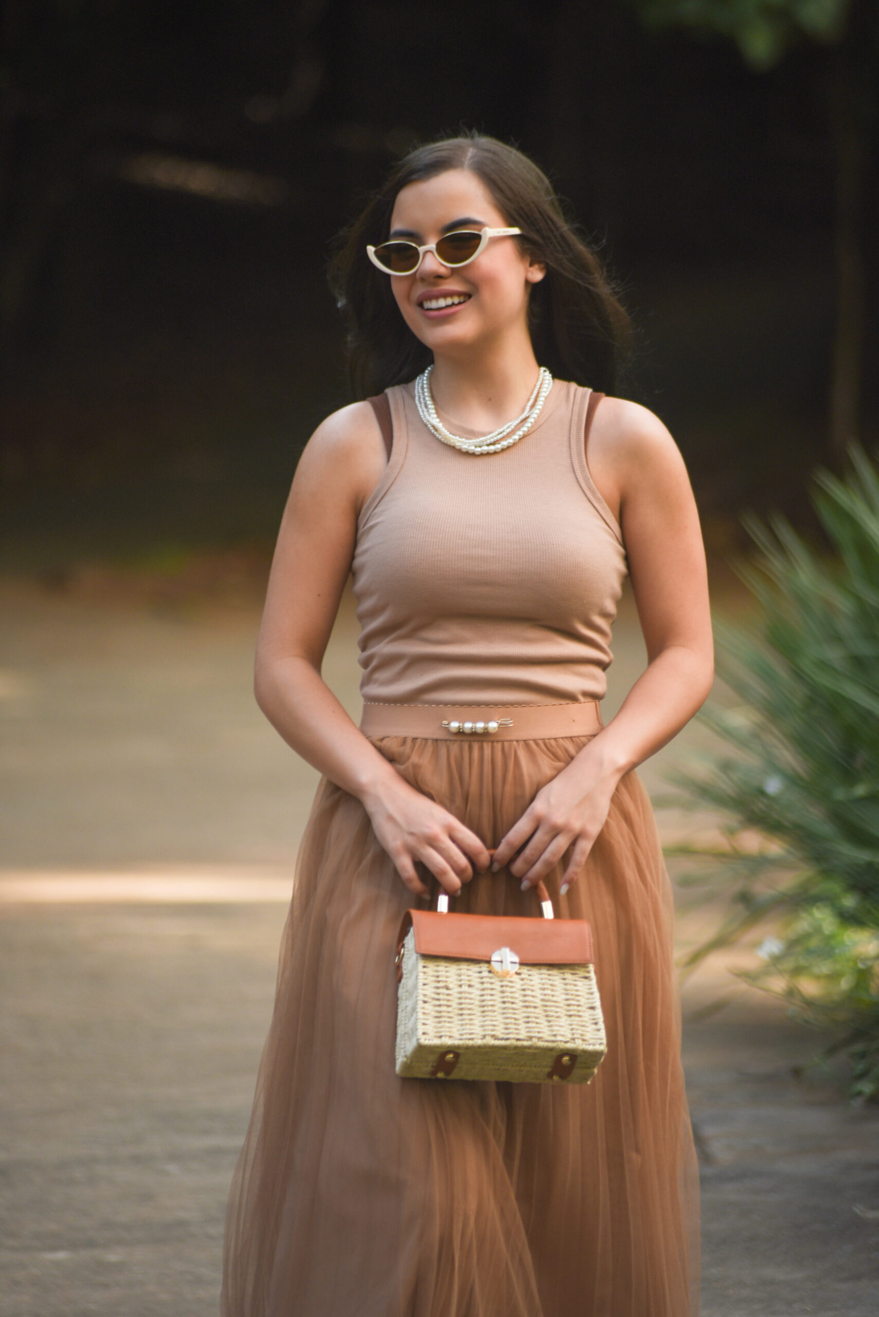 Sophia Ferreira vestindo alfaiataria elegante com acessórios dourados, representando sua trajetória como empreendedora e estrategista de branding de luxo.
