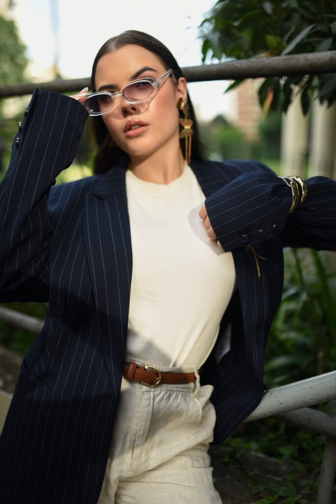 Sophia Ferreira caminhando ao ar livre com um look sofisticado em tons neutros, expressando elegância, moda de luxo e presença digital no mercado premium.