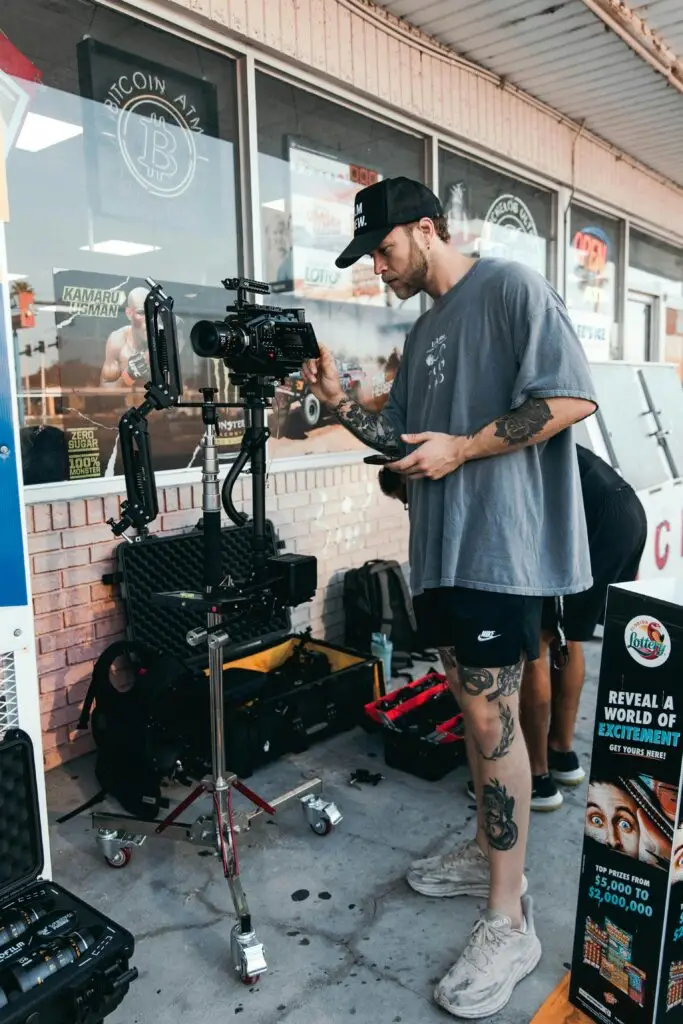 Cinegrafista profissional ajustando uma câmera de alta performance em um estabilizador, preparando a filmagem de um conteúdo para campanhas visuais externas.