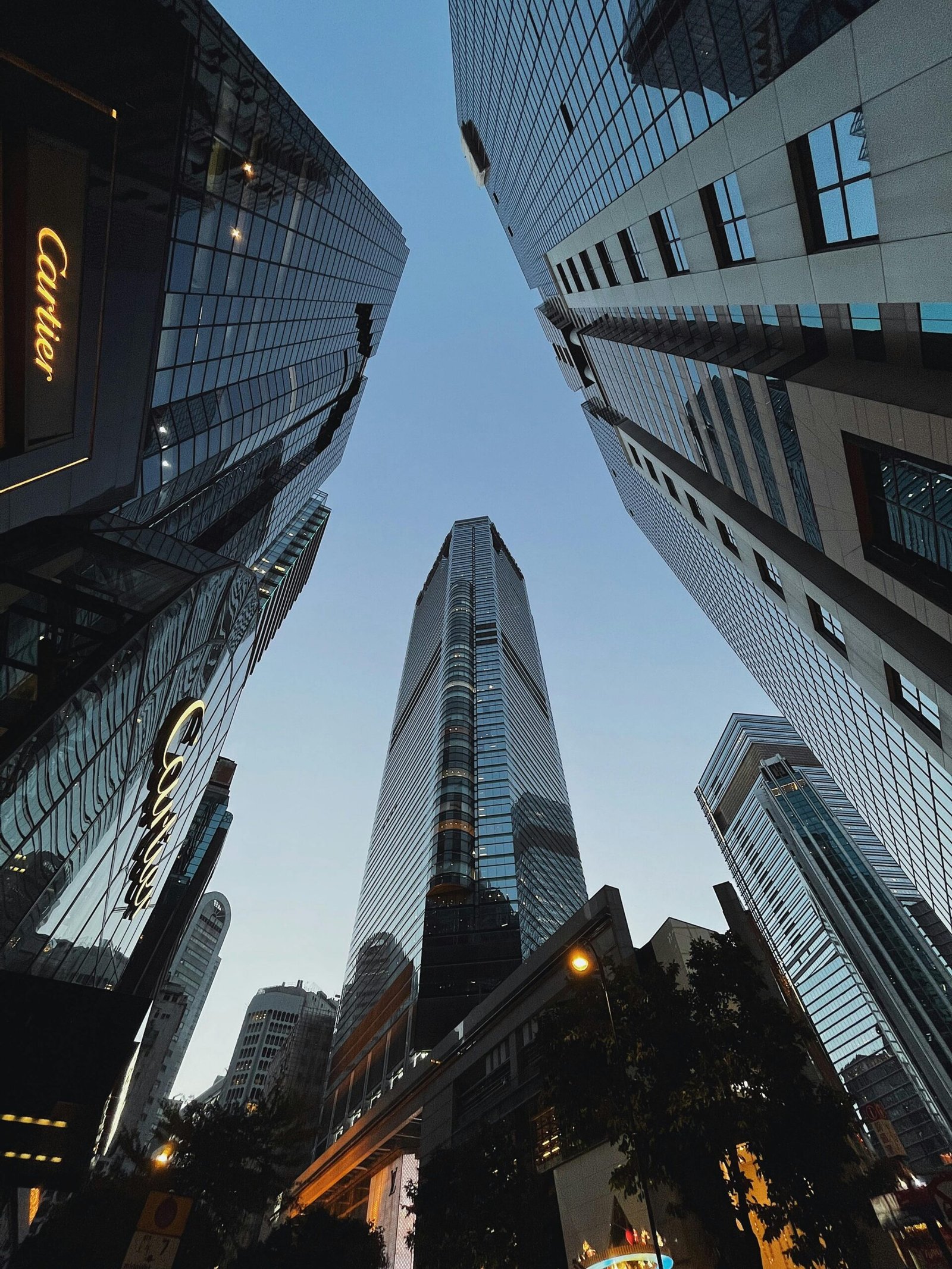 Vista de arranha-céus de luxo com a fachada iluminada da Cartier, representando a exclusividade e sofisticação das grandes marcas no mercado global.